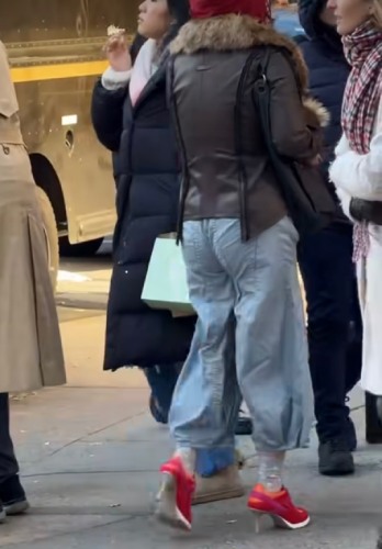 maroon hoodie beneath a leather-and-fur coat